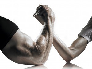 a heavily muscled man arm wrestling a thin weal man